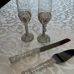 Champagne flutes with cake and knife set covered in silver rhinestones.